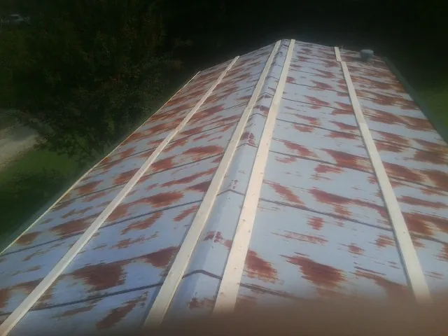 Rusted metal roof panels with new wood purlins before replacement — Storm Damage Roof Repair in Wetmore by Roofing Brothers