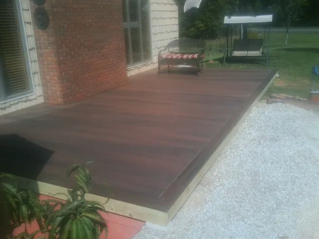 Freshly stained wood deck built against a brick home in Wetmore