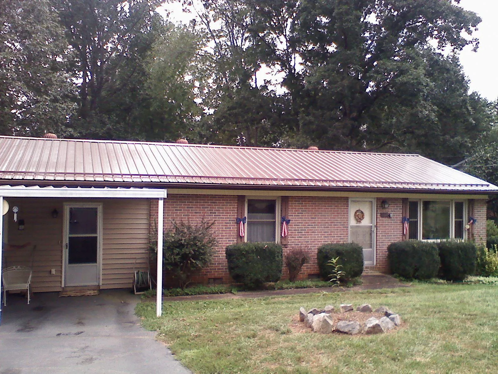 Bronze metal roof and carport on a brick ranch home — Roof Repair work by our crew in Wetmore